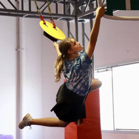 Girl swinging on grips during ninja class at Ninja Republic in San Mateo, CA