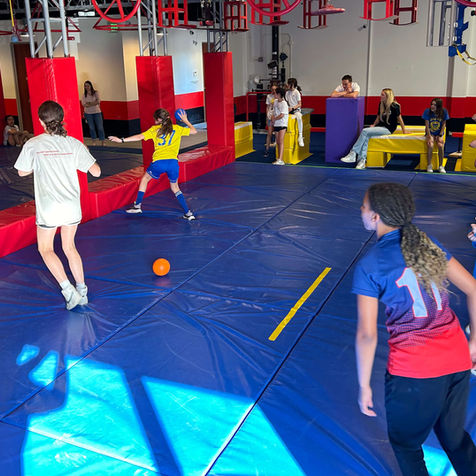 Children running on a blue mat