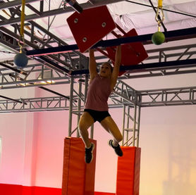 Child climbing red ninja rig structure at Ninja Republic in San Mateo, CA