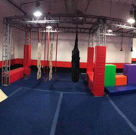 Wide view of warped wall and obstacle course at Ninja Republic in San Mateo, CA